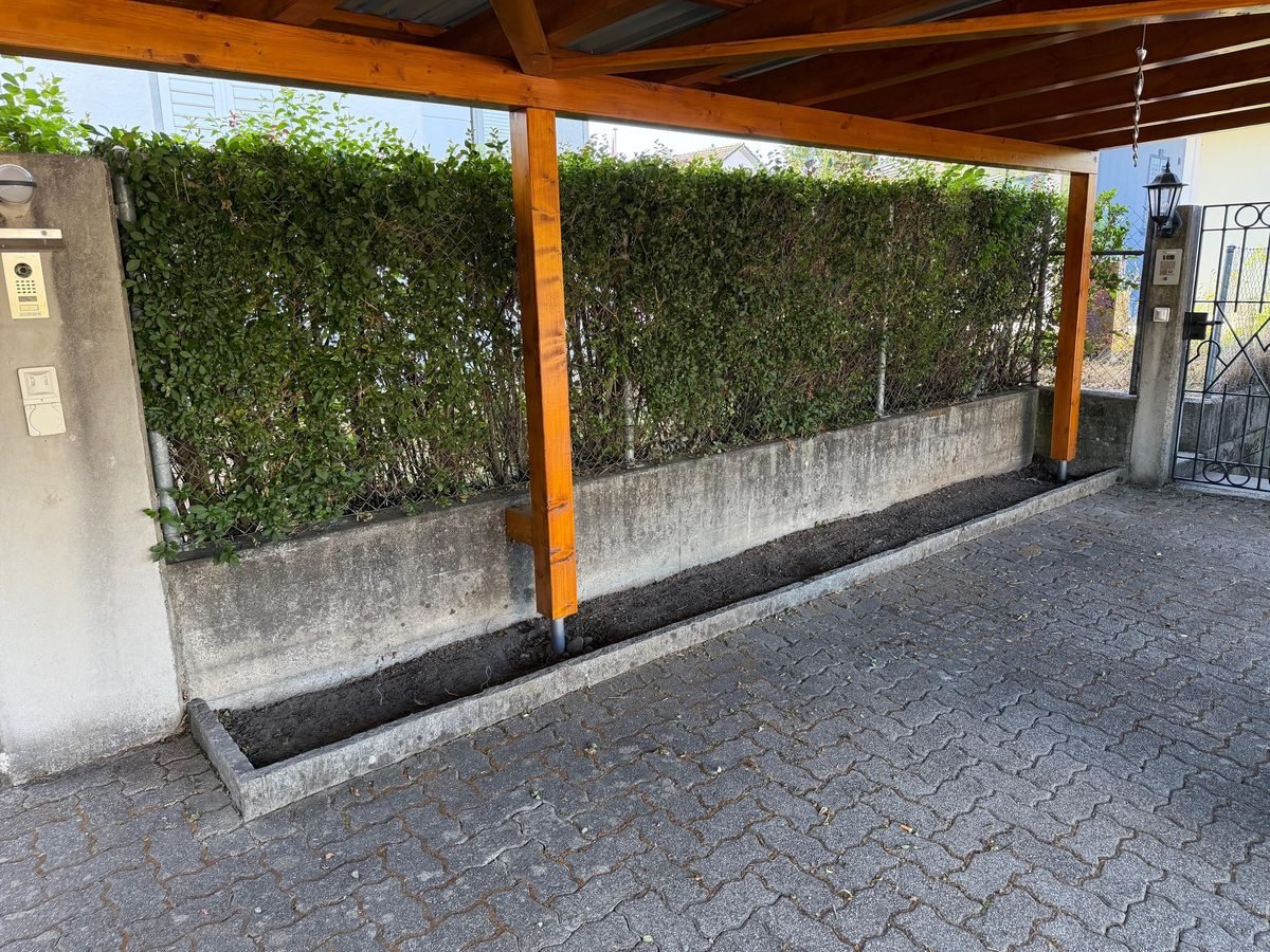 Offener Erdstreifen entlang der Mauer unter dem Carport, vor der Verlegung